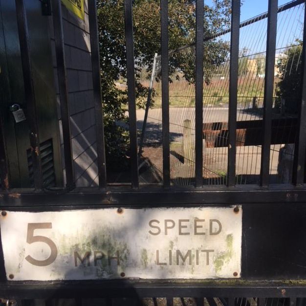 Sign on an iron gate reads “5 MPH Speed Limit”.